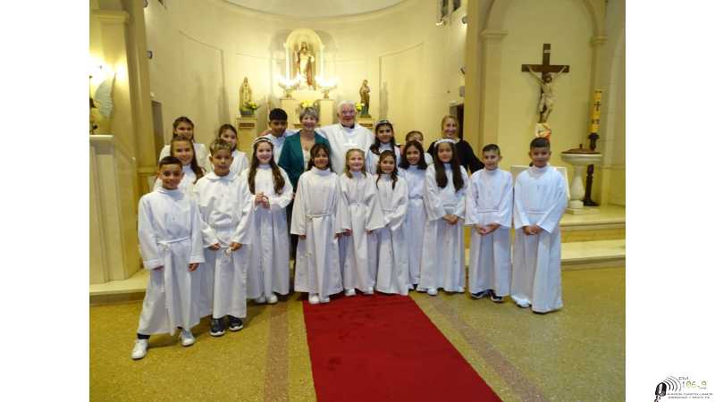 Primera comunión por el Padre Daniel, párroco de la Parroquia Sagrado Corazón de Jesús a los niños